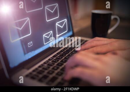 Icone e-mail che provengono dallo schermo di un personal computer Foto Stock