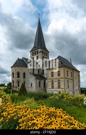 Abbazia storica in Normandia con fiori gialli e cielo espressivo e il paesaggio nuvoloso Foto Stock