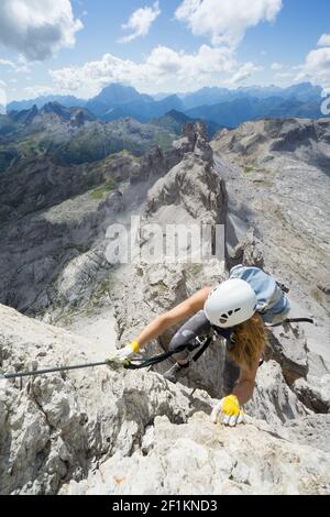 Attraente scalatore femminile su una ripida Via Ferrata nel Dolomiti Italiane Foto Stock