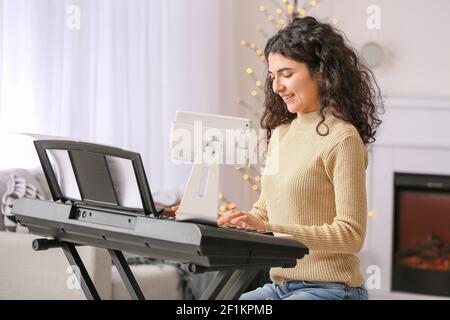 Giovane donna che dà lezioni di musica on-line a casa Foto Stock