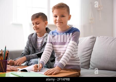 I piccoli ragazzi carini che fanno i compiti a casa Foto Stock
