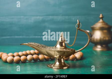 Lampada Aladdin di desideri e tasbih su sfondo a colori Foto stock - Alamy