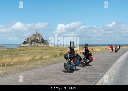 Turisti in bicicletta a lunga distanza in visita e in viaggio per il famoso Mont Saint-Michel nel nord p. Foto Stock