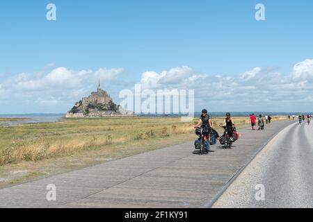 Turisti in bicicletta a lunga distanza in visita e in viaggio per il famoso Mont Saint-Michel nel nord p. Foto Stock