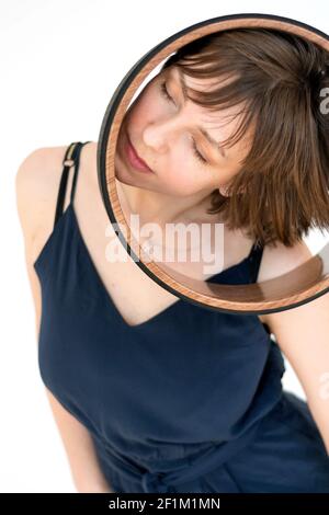 Donna è impegnata con un anello di yogi sulla sua testa Foto Stock