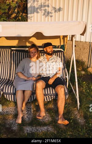 Coppia seduta su panca swing Foto Stock