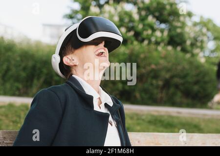 Donna felice che indossa il visore VR Foto Stock