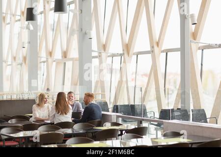 Colleghi che si riuniscono al caffè dell'aeroporto Foto Stock