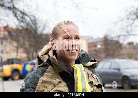 Sorridente pompiere femmina che guarda via Foto Stock