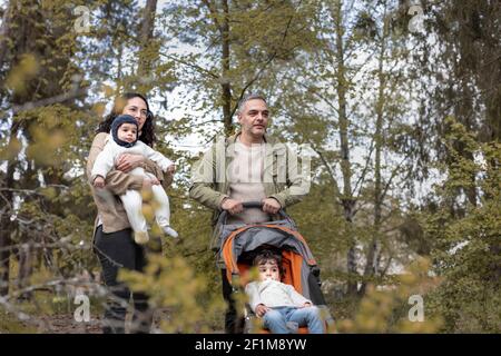 Genitori con due bambini che camminano Foto Stock