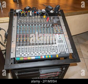 Console Sound ENGINEER con prese e dispositivi audio collegati in una sala concerti Foto Stock
