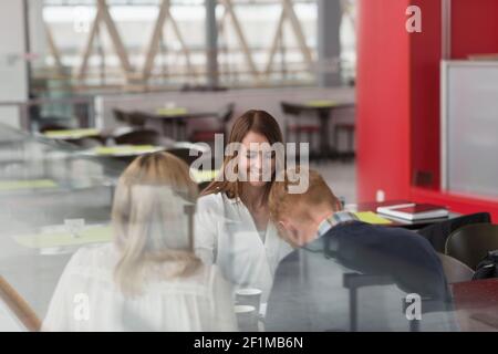 Colleghi che si riuniscono al caffè dell'aeroporto Foto Stock