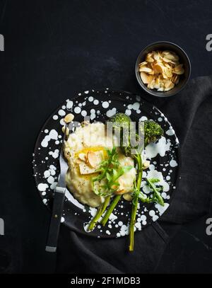 Schiacciare le patate con i broccoli sul piatto Foto Stock