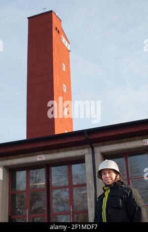 Pompiere femminile di fronte alla stazione dei vigili del fuoco Foto Stock