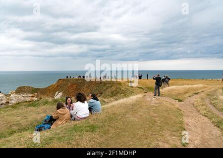 I turisti possono fare escursioni e fare un picnic lungo la costa della Normandia Il Falaise de Etretat scogliere abov Foto Stock