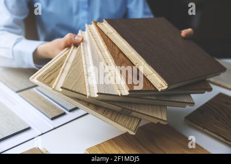 pavimento in parquet - negozio venditore con campioni di pavimenti in mani Foto Stock