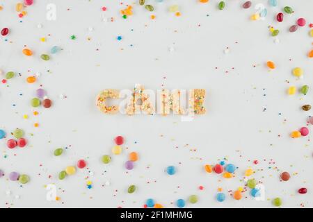 Torta di parole fatta di biscotti di zucchero, caramelle colorate e spruzzare intorno Foto Stock