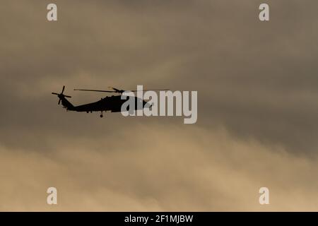 Silhouette di un elicottero US Navy Sikorsky SH-60R Seahawk con il Maritime Strike Squadron 51 contro un cielo nuvoloso e crepuscolo vicino alla base aerea Atsugi, Kanagawa, Giappone Foto Stock