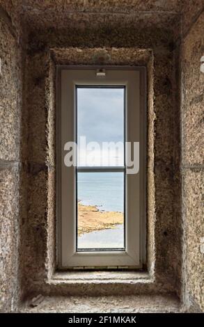 Vista dell'oceano attraverso una finestra del faro nella scala in pietra Foto Stock