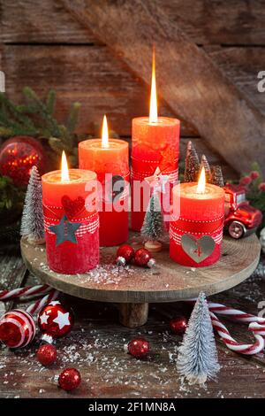 Quattro candele e decorazioni festive Foto Stock