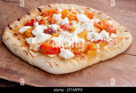 bruschetta fatta in casa su conchiglia di pizza con pomodori di primo apparire e formaggio di capra Foto Stock