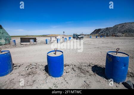 Khromtau, regione di Aktobe, Kazakhstan - 06 maggio 2012: Miniera d'oro. Balaustra da strada fatta a mano di barile in plastica con calcestruzzo. Parte del portale della miniera a sinistra. Foto Stock