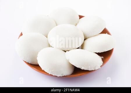 Folle o Idli, l'articolo principale della colazione dell'india del sud che è organizzato splendidamente in un'attenzione di terra con sfondo bianco. Foto Stock