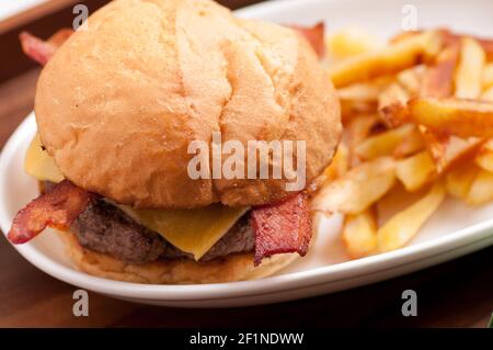 hamburger biologico fresco fattoria con pancetta e formaggio con casa patatine fritte fatte Foto Stock