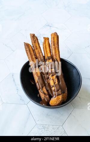 Churros Sticks con salsa al cioccolato . Pasta fritta Pasticceria tradizionale spagnola o messicana Dessert. Pronto a servire e mangiare. Foto Stock