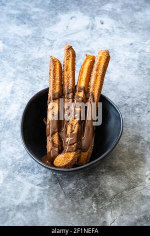 Churros Sticks con salsa al cioccolato . Pasta fritta Pasticceria tradizionale spagnola o messicana Dessert. Pronto a servire e mangiare. Foto Stock
