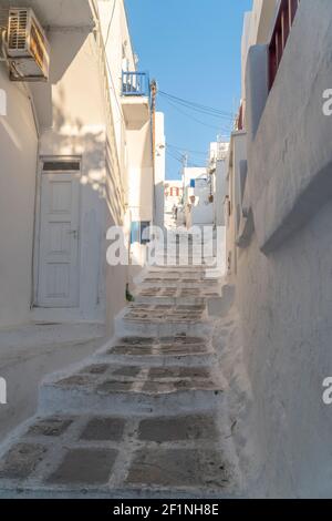 Bianche stradine con finestre e porte in una giornata di sole con cielo blu a Mykonos, isola greca Foto Stock
