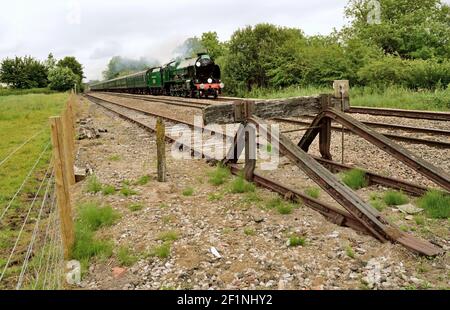 Una fermata arrugginita segna la fine del siding a Great Bedwyn, mentre il Cathedrals Express passa sulla strada per Bristol. Foto Stock