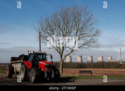 Ratcliffe-on-Soar, Nottinghamshire, Regno Unito. 9 marzo 2021. Un agricoltore lavora vicino alla centrale elettrica Ratcliffe-on-Soar, mentre il Consiglio borough di Rushcliffe discuterà di un'espressione di interesse per la centrale elettrica alimentata a carbone di UniperÕs per ospitare un reattore di fusione nucleare quando sarà smantellato nel 2025. Credit Darren Staples/Alamy Live News. Foto Stock