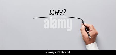 Mano dell'uomo d'affari che scrive la domanda perchè su sfondo grigio. Mettere in discussione e analizzare il concetto aziendale. Foto Stock