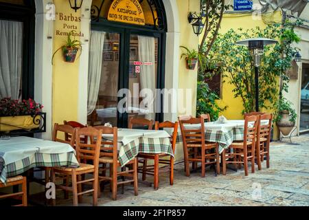 Kerkyra, isola di Corfù, Grecia – 4 maggio 2019: Paesaggio urbano con caffetteria tradizionale – sedie e tavoli in legno d'epoca, finestre e pareti, decorate con mobili in legno Foto Stock