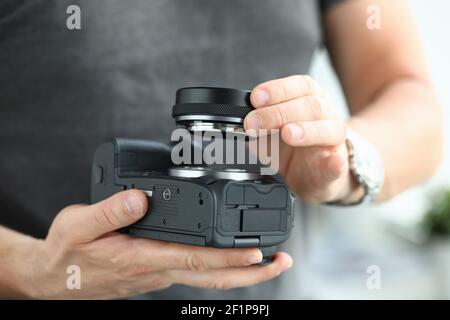 Mani maschili che indossano un moderno adattatore per obiettivo per fotocamera digitale Foto Stock