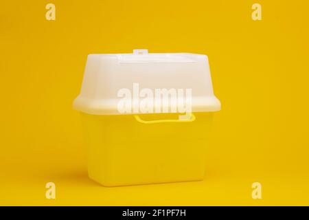 Contenitore con tappo bianco su fondo giallo senza cuciture per lo smaltimento degli aghi iniettori usati con residui di farmaco. Foto Stock