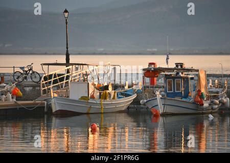 Paesaggio tramonto con vista sulle tradizionali barche da pesca greche al porto di Paralio Astros in Arcadia, Grecia Peloponneso. Foto Stock