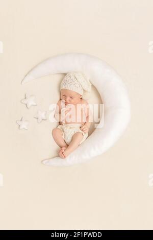 Cute bambino che dorme su un cuscino a forma di luna Foto Stock