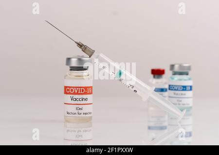 vaccine covid-19 flaconcini di vaccino con siringa, su fondo bianco Foto Stock
