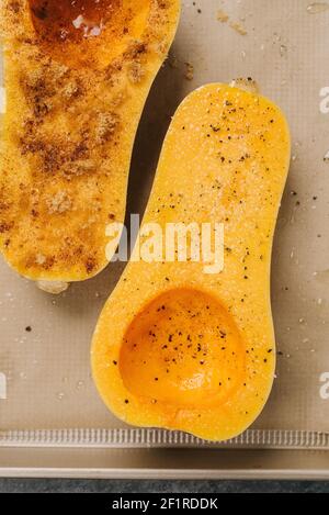 Zucca di butternut a metà condita e pronta a cuocere Foto Stock