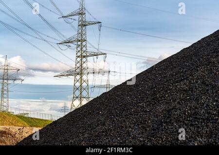 Discarica di carbone, giacenza di carbone, centrale di carbone, per la centrale termica combinata STEAG Herne, piloni ad alta tensione, sul canale Reno-Herne, Herne Foto Stock