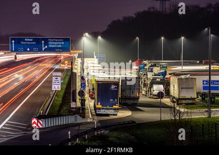 Traffico pesante sulla A2 nella zona di riposo Schwarze Heide, Bottrop, parcheggio sovraffollato per camion in serata, Bottrop, NRW, Germania Foto Stock