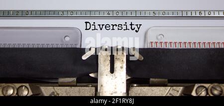 Simbolo di inclusione e diversità. La parola 'diversità' digitata su una macchina da scrivere retrò. Concetto di business, inclusione e diversità. Splendido sfondo. Foto Stock