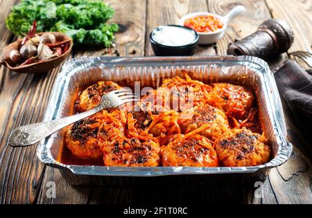 Polpette in salsa di pomodoro cotte in un contenitore di alluminio. Foto Stock