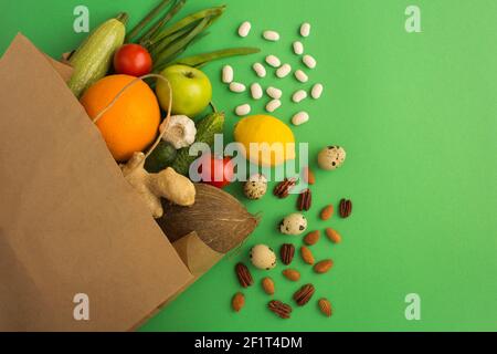 Sacchetto di carta di verdure e frutta su sfondo verde. Concetto di cibo in sacchetto. Vista dall'alto.Copia spazio. Foto Stock
