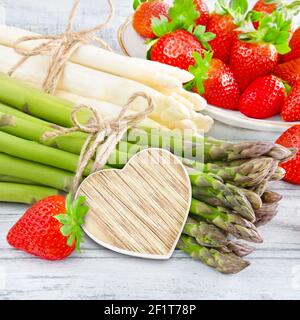Erdbeeren und Erdbeeren von Herz auf Holz Foto Stock