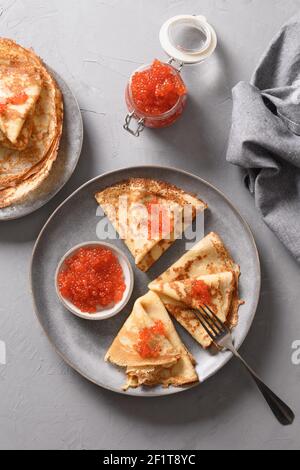 Frittelle russe sottili con caviale rosso. Shrovetide. Maslenitsa tradizionale pasto del festival russo. Vista dall'alto. Foto Stock