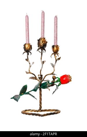 Un candelabro forgiato in metallo sotto forma di boccioli di rosa con tre candele si trova su un supporto ritorto con una rosa rossa forgiata isolata su uno sfondo bianco. Foto Stock