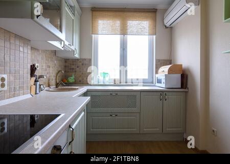 Frammento di una cucina ad angolo all'interno di la cucina con una grande finestra Foto Stock
